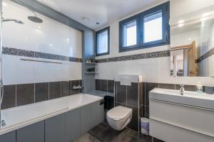 a bathroom with a tub and a toilet and a sink at Les Coteaux 2 - 5 chambres proche CDG in Argenteuil