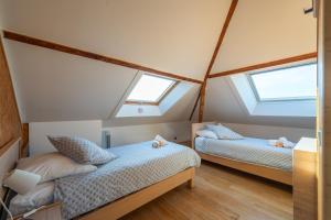 two beds in a small room with two windows at Les Coteaux 2 - 5 chambres proche CDG in Argenteuil