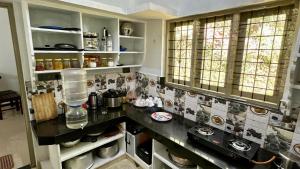a kitchen with a counter and some shelves and windows at Morning Hills in Munnar