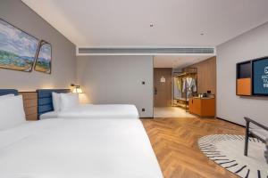 Golden Tulip Qingdao Hongdao Exhibition Center Hotel客房内的一张或多张床位