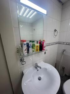 um banheiro com pia branca e espelho em Smile Apartment Sharjah -FAMILY ONLY em Sharjah