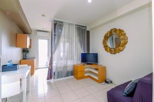 Una televisión o centro de entretenimiento en Comfortable and Tidy Studio at Titanium Square Apartment By Travelio