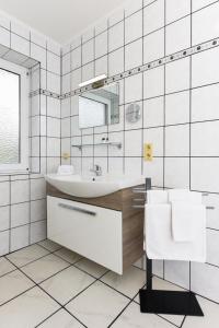 ベンサージールにあるHaus Hafeneck FeWo Ebbeの洗面台と鏡のある白いバスルーム