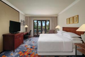 una camera d'albergo con un letto e una televisione di AKAR Hotels & Resort Lampung a Bandar Lampung