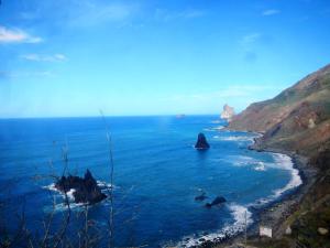 a view of the ocean with rocks in the water at Albergue Montes de Anaga in El Bailadero