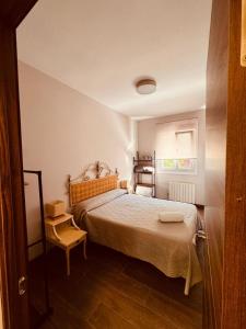 een kleine slaapkamer met een bed en een stoel bij 16 Mirasierras in Madrid