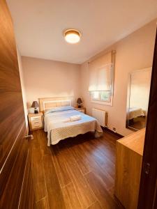 een slaapkamer met een bed en een houten vloer bij 16 Mirasierras in Madrid