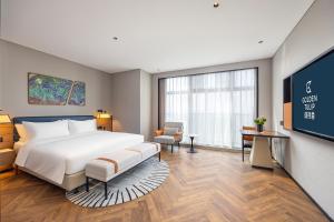 Golden Tulip Qingdao Hongdao Exhibition Center Hotel客房内的一张或多张床位