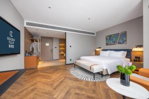 青岛Golden Tulip Qingdao Hongdao Exhibition Center Hotel的一间带床和电视的酒店房间 更多37张照片