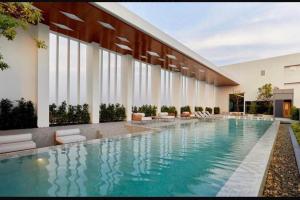 a swimming pool with chairs and a building at Escent condo chiangmai A in Chiang Mai