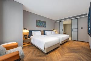 Golden Tulip Qingdao Hongdao Exhibition Center Hotel客房内的一张或多张床位