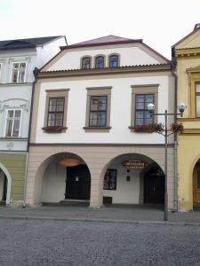 duży biały budynek z łukami na ulicy w obiekcie Apartments U Kašny w mieście Kadaň