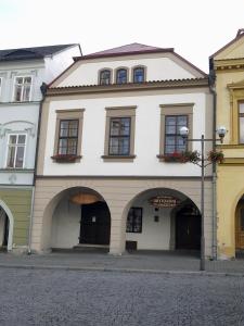 a large white building with arches on a street at Apartments U Kašny in Kadaň