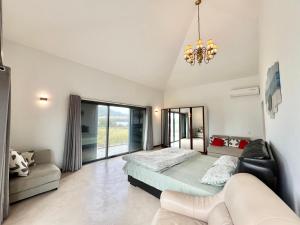 a bedroom with a bed and a couch at Coral Residence Luxury Villa in Vieux Grand Port +26 photos