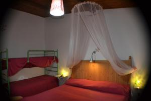 a bedroom with two beds and a mosquito net at B&B Le Stagioni in Castel del Monte