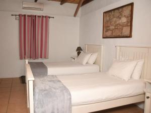 two beds sitting next to each other in a room at The Old Village in Citrusdal