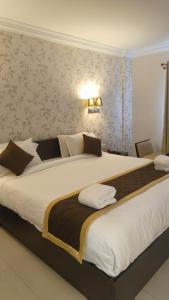 安加马尔伊Hotel Grand Regency, Angamaly的一张大床,位于酒店客房内,配有一张白色大床