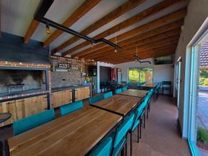 a dining room with wooden tables and blue chairs at Koliba La Perla in Banja Luka