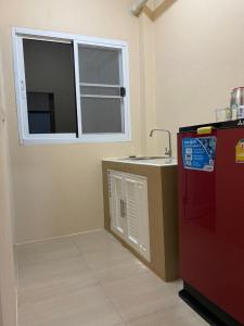 eine Küche mit einer Spüle und einem roten Kühlschrank in der Unterkunft แม่พริกธารา แม่สรวย in Ban Mae Phrik (1)