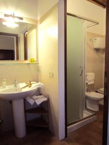a bathroom with a sink and a toilet and a mirror at B&B Le Logge Di Sopra in Asciano