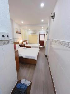 a hotel room with two beds and a living room at Khách sạn Thy Thảo in Ho Chi Minh City +3 photos