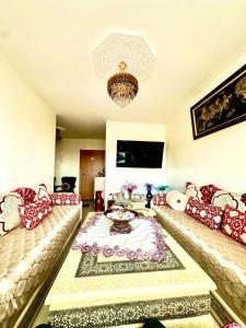 a living room with two couches and a table at Apprt cosy près plage des Nations in Sale +14 photos