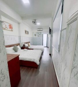 a hotel room with two beds and a hallway at Khách sạn Thy Thảo in Ho Chi Minh City