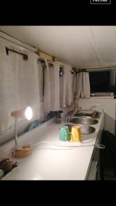 a kitchen counter with a sink and a lamp at vacances de rêve sur les vagues in Gruissan