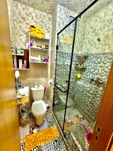 a bathroom with a toilet and a glass shower at Apprt cosy près plage des Nations in Salé +14 photos