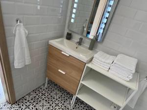 バラトンマーリアフュルドゥーにあるÍrisz Apartman teljes házの洗面台と鏡のある白いバスルーム +36枚の写真