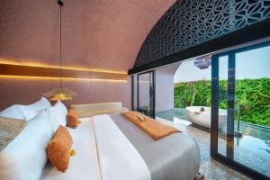 Un dormitorio con una cama grande y una bañera. en Seascape Resort & Spa Sanur by Ini Vie Hospitality, en Sanur