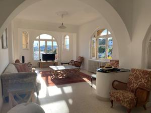 ein Wohnzimmer mit Stühlen und einem Tisch in der Unterkunft Grande maison et piscine privée in Saint-Ambroix