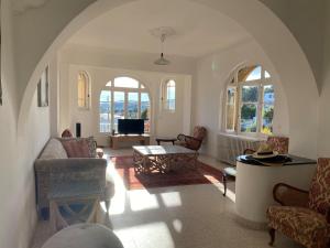 ein Wohnzimmer mit einem Torbogen mit Stühlen und einem Tisch in der Unterkunft Grande maison et piscine privée in Saint-Ambroix