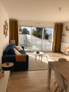 a living room with a couch and a table at Appartement cosy à 100m de la plage in La Bernerie-en-Retz