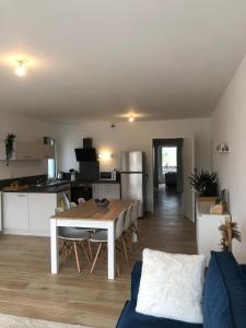 a living room with a table and a kitchen at Appartement cosy à 100m de la plage in La Bernerie-en-Retz