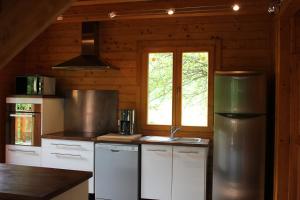 eine Küche mit weißen Schränken und einem Fenster in der Unterkunft Le Chalet du Berger in Briançonnet