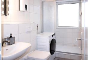 a white bathroom with a toilet and a sink at Gemütliche 2-Zimmer Wohnung, zentrale Lage, Smart TV in Bahnhof Essen Süd