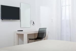a bedroom with a desk with a chair and a television at Princess Of Naxos in Naxos Chora