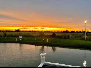 a boat in the water with a sunset in the background at 8 Berth 3 bed caravan Golden palm ML9 in Chapel Saint Leonards