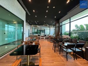 a restaurant with tables and chairs and windows at D'Edge Thao Dien - SkyPool Paradise in Ho Chi Minh City