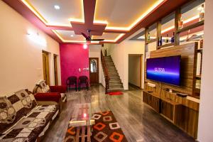 a living room with a couch and a flat screen tv at San WAYANAD HOMESTAY AND SERVICE VILLA in Sultan Bathery