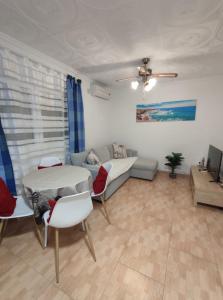 a living room with a couch and a table and chairs at Espanhouse Diana bungalow in La Mata