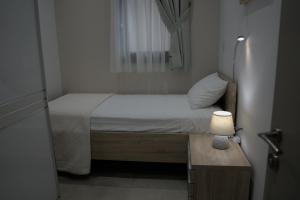 a small bed in a small room with a lamp at Sunrise Room 2 in Igoumenitsa