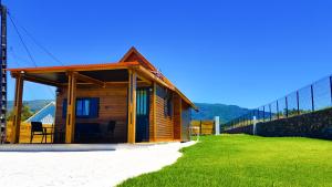 a small wooden house on a beach next to a fence at Au Châlet in Le Tampon
