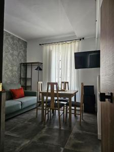 Un comedor con una mesa y sillas y un sofá. en Suite Foro Romano 2 huespedes, en Córdoba