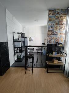eine Küche mit einer Theke und Hockern in einem Zimmer in der Unterkunft Parque Caminho das Baraúnas in Caruaru