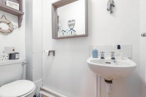 a bathroom with a sink and a mirror and a toilet at Stoney Creek Cottage - Crail in Crail +12 photos