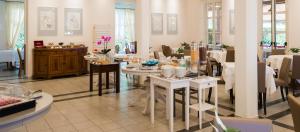 a dining room with white tables and chairs at Hotel Regina in Forte dei Marmi