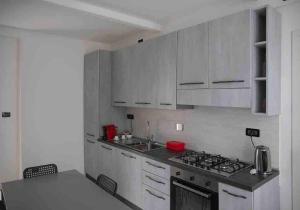 Una cocina con gabinetes blancos y un horno de estufa. en Luxury City Retreat with Breathtaking View, en Turín 12 fotos más