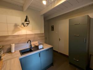 ostfriesisches Ferienhaus Anno 1899 في Großheide: مطبخ مع حوض وثلاجة